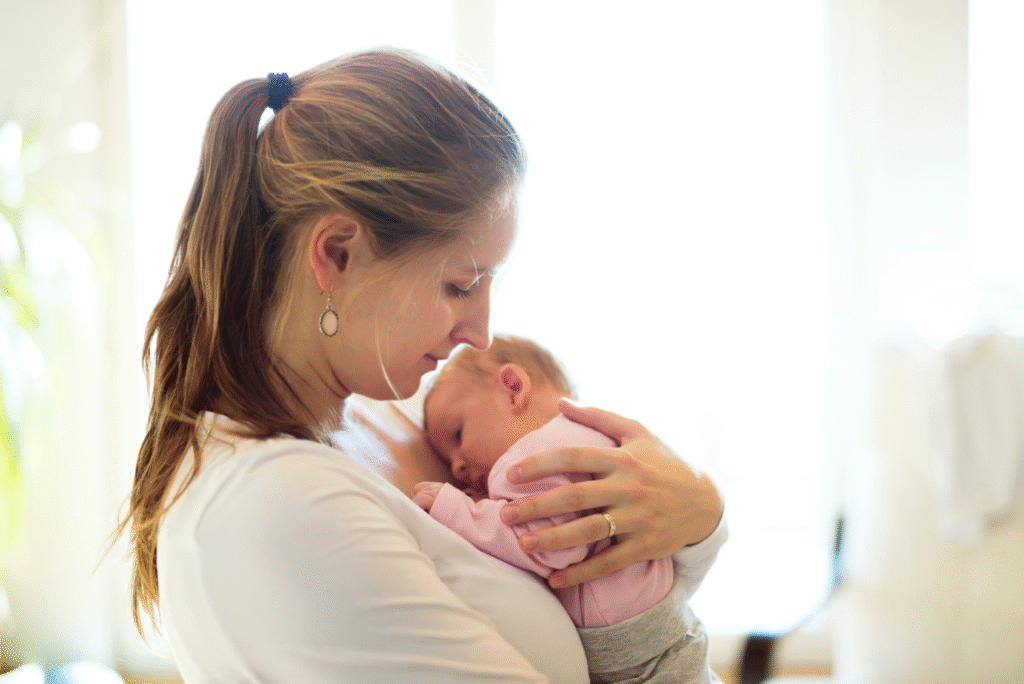 Mom holding newborn baby while looking lovingly